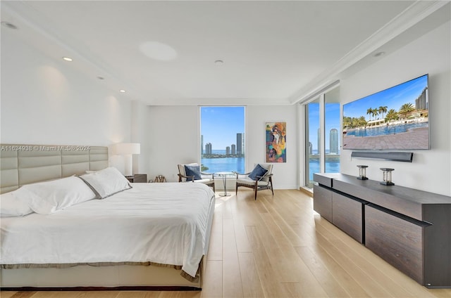 bedroom featuring access to outside, light wood-type flooring, and crown molding