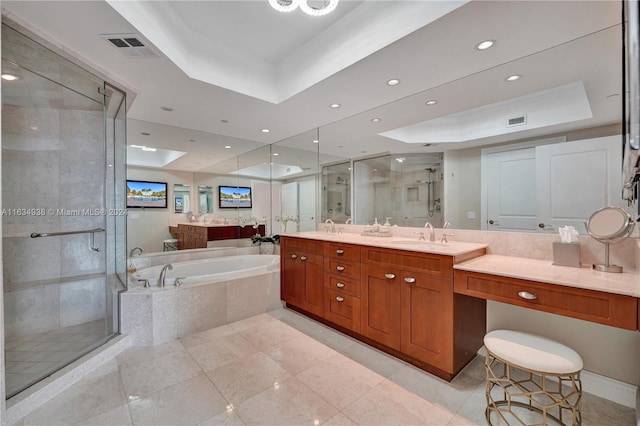 bathroom with a raised ceiling, vanity, plus walk in shower, and tile patterned flooring