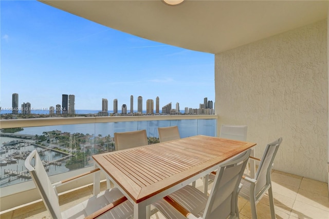 balcony with a water view, a view of city, and outdoor dining area