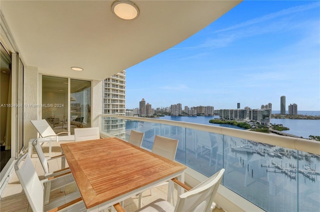 balcony with a water view, a view of city, and outdoor dining area