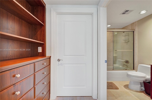 full bathroom with toilet, recessed lighting, shower / bath combination with glass door, visible vents, and tile patterned floors