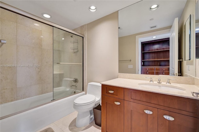 full bathroom with shower / bath combination with glass door, vanity, tile patterned flooring, and toilet