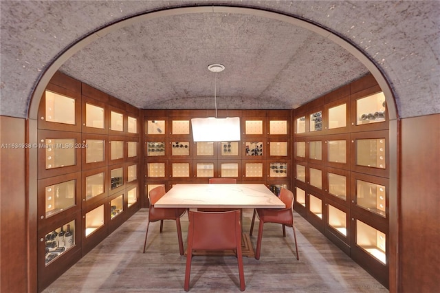 dining space with vaulted ceiling and hardwood / wood-style floors