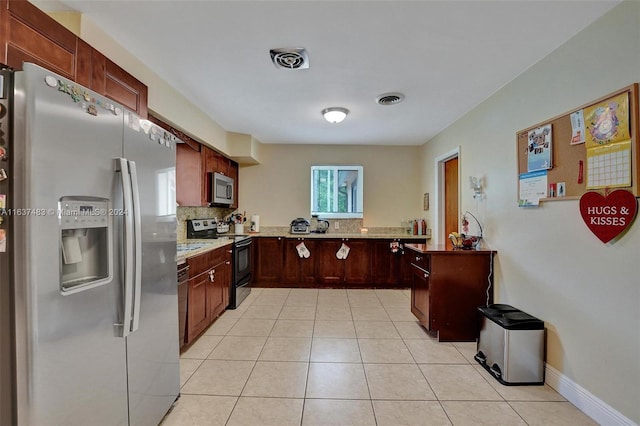 kitchen featuring appliances with stainless steel finishes, tasteful backsplash, light stone counters, and light tile patterned flooring