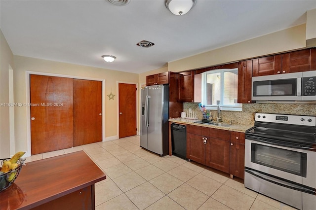 kitchen featuring light tile patterned floors, sink, appliances with stainless steel finishes, and tasteful backsplash