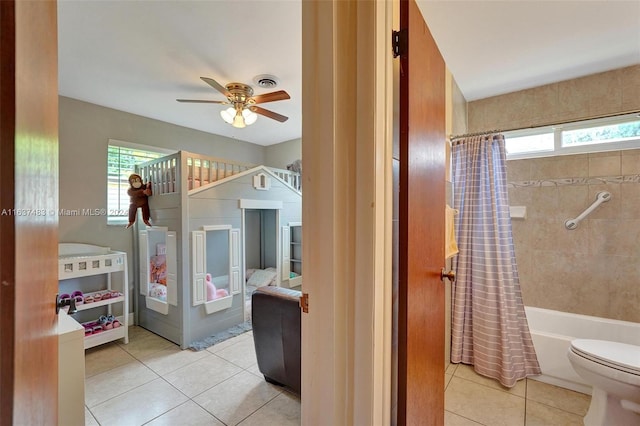 interior space featuring ceiling fan, light tile patterned floors, and multiple windows