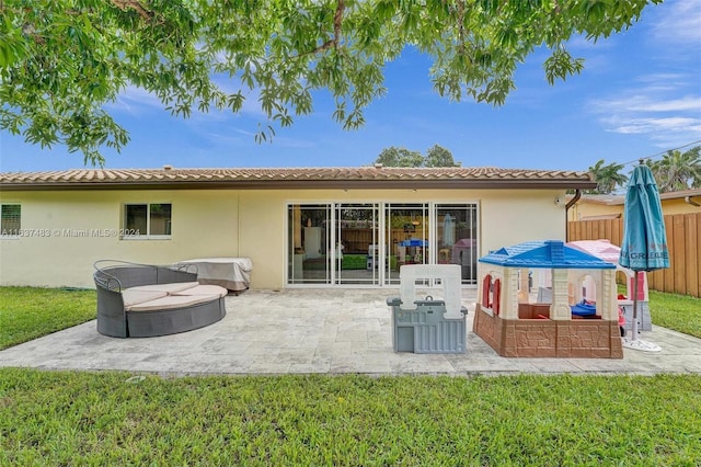 back of house with a lawn and a patio