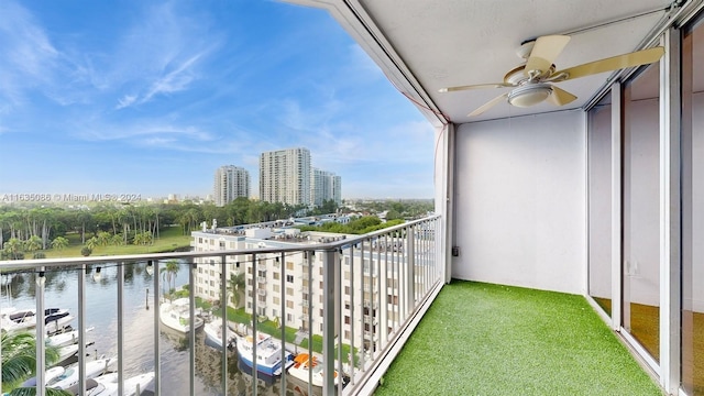 balcony featuring a water view and ceiling fan