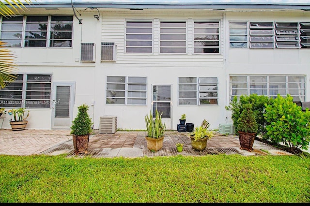 back of house featuring central AC unit, a patio area, and a yard