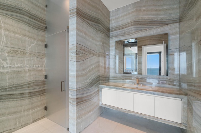 bathroom with tile patterned flooring, tile walls, and vanity