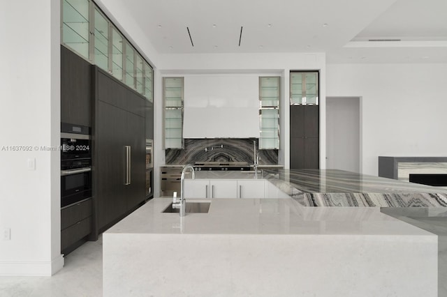 kitchen featuring sink, tasteful backsplash, black double oven, and a tray ceiling