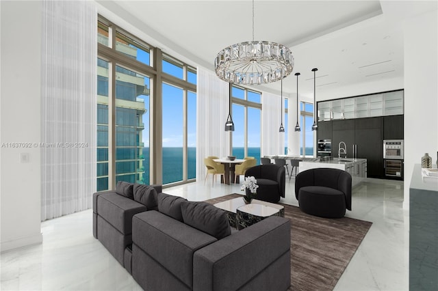 tiled living room with sink, a wall of windows, a chandelier, and a water view