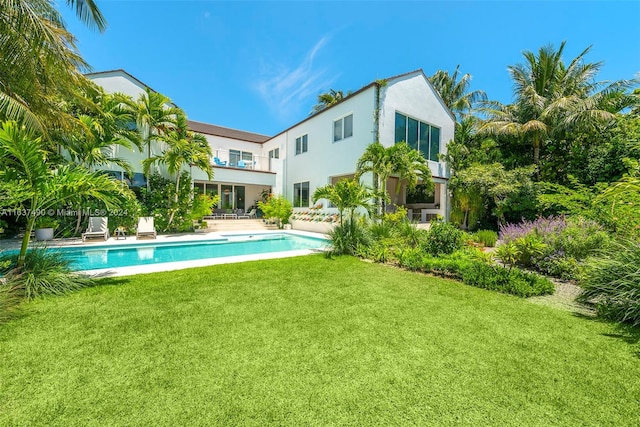 back of property featuring a lawn and a patio area