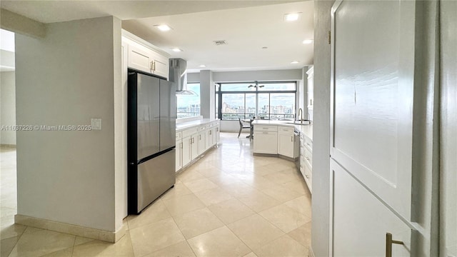 kitchen with stainless steel appliances, white cabinetry, sink, and light tile patterned floors