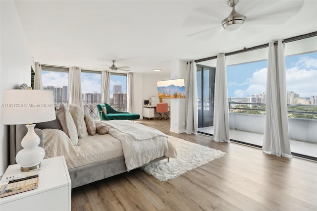 bedroom with ceiling fan, hardwood / wood-style floors, and expansive windows