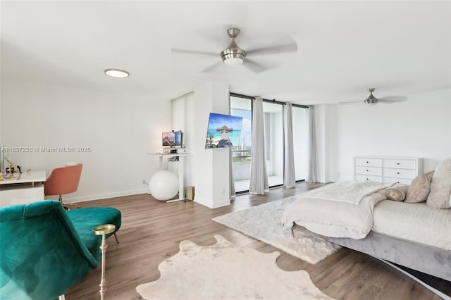 living room with hardwood / wood-style flooring, ceiling fan, and a wall of windows