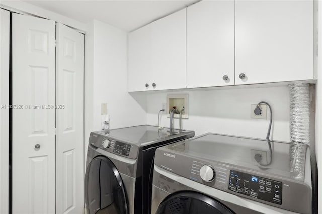 laundry area with separate washer and dryer and cabinets