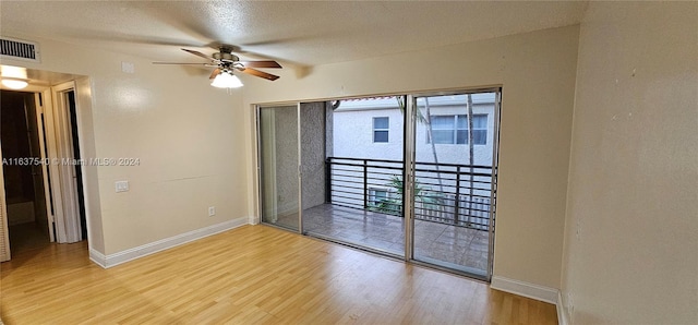 spare room with a ceiling fan, baseboards, visible vents, and wood finished floors