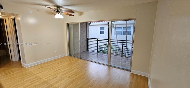 unfurnished room with a ceiling fan, visible vents, baseboards, and wood finished floors