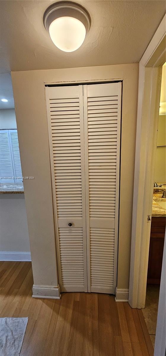 interior details with a textured ceiling, wood finished floors, and baseboards