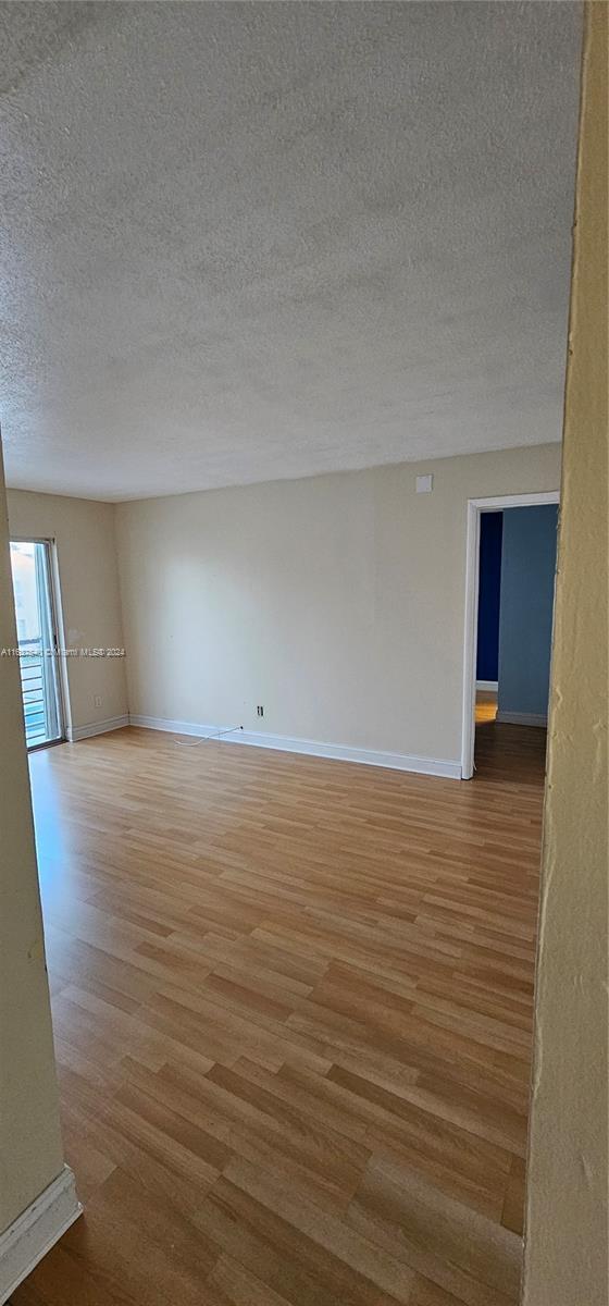 unfurnished room featuring a textured ceiling and hardwood / wood-style flooring