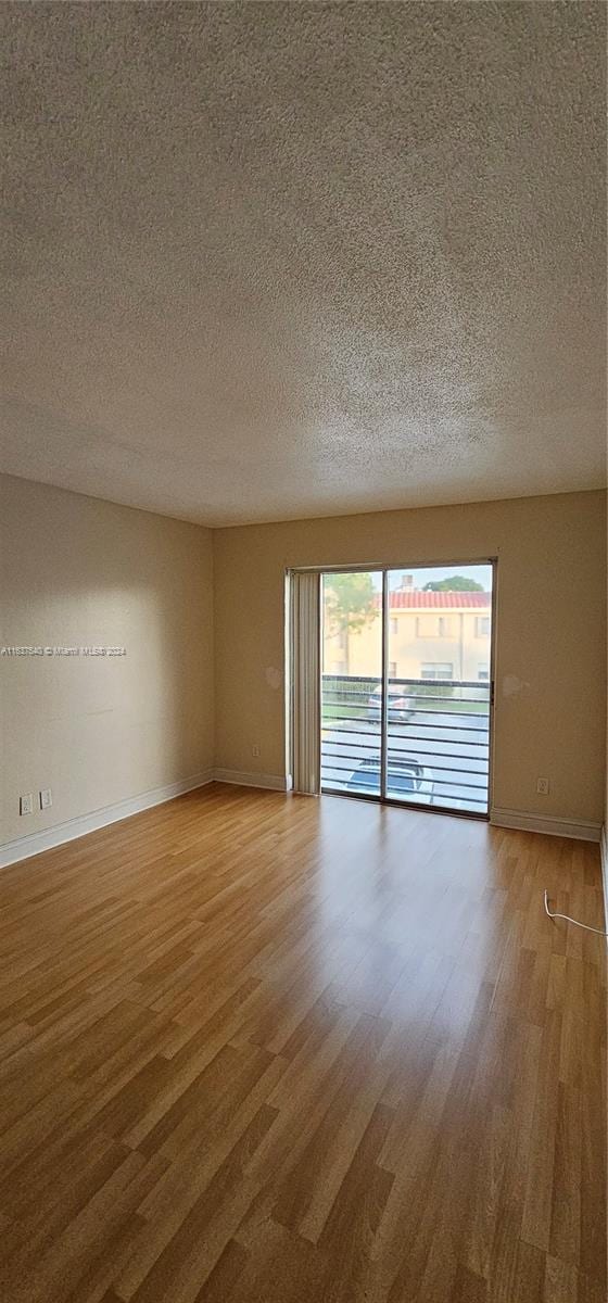 empty room featuring a textured ceiling and hardwood / wood-style flooring