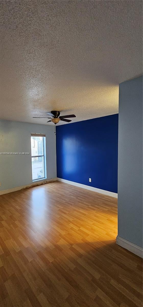 unfurnished room featuring a textured ceiling, ceiling fan, and hardwood / wood-style floors