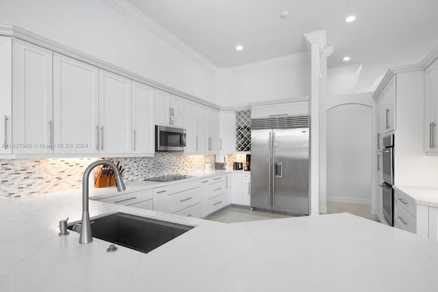 kitchen with crown molding, tasteful backsplash, white cabinets, stainless steel appliances, and sink