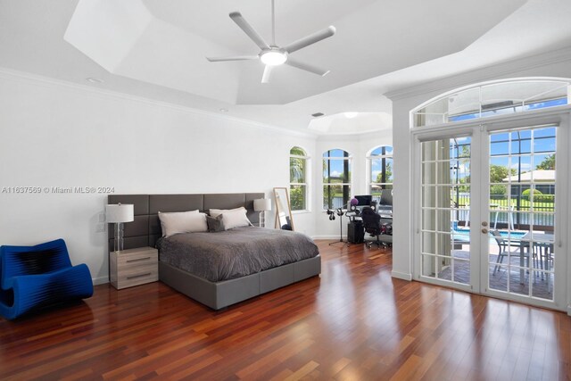 bedroom with wood-type flooring, ceiling fan, a tray ceiling, ornamental molding, and access to exterior