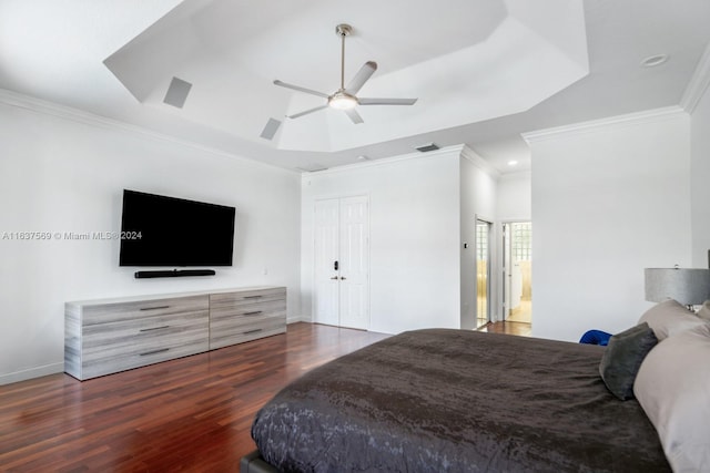 bedroom featuring ceiling fan, dark hardwood / wood-style floors, and a tray ceiling