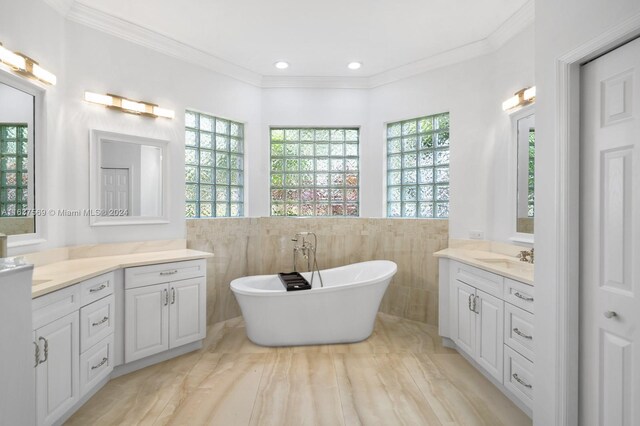 bathroom with vanity, a wealth of natural light, crown molding, and tile walls