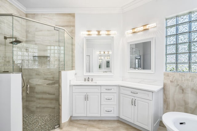 bathroom with tile patterned floors, tile walls, a shower with shower door, ornamental molding, and dual bowl vanity