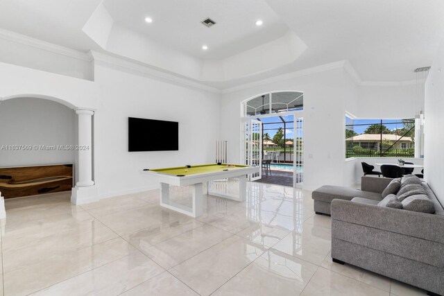 living room with a tray ceiling, a healthy amount of sunlight, light tile patterned floors, and billiards