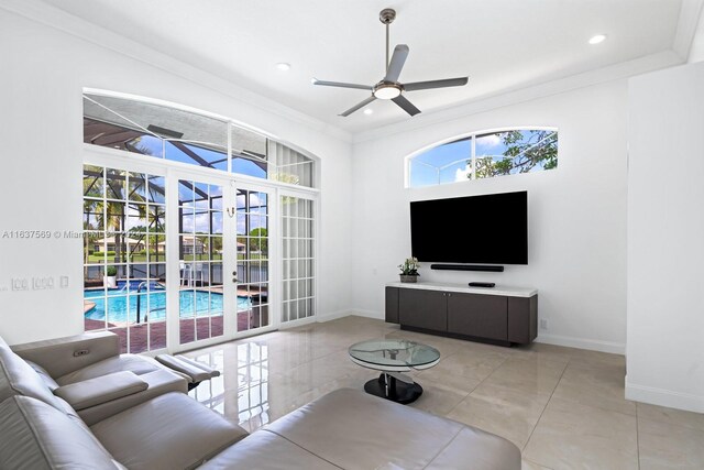 living room featuring ornamental molding, light tile patterned flooring, and ceiling fan