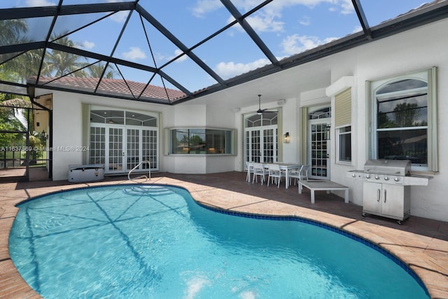 pool featuring a lanai, area for grilling, a ceiling fan, french doors, and a patio area