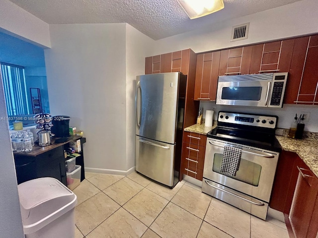3300 NE 191st St Unit 515, Aventura, FL 33180 - kitchen featuring stainless steel appliances, a textured ceiling, light tile patterned floors, and light stone countertops