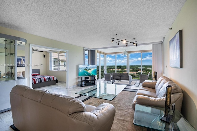 living room with a textured ceiling, plenty of natural light, ceiling fan, and expansive windows