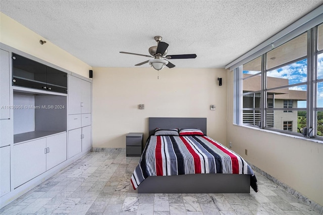 bedroom featuring ceiling fan and a textured ceiling