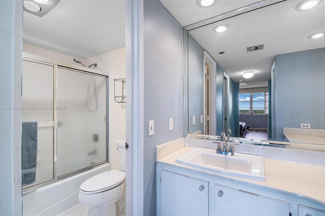 full bathroom featuring a textured ceiling, combined bath / shower with glass door, tile patterned floors, vanity, and toilet