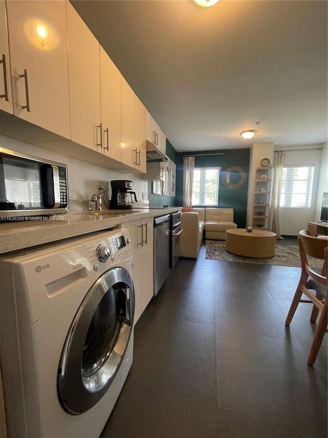 washroom with washer / clothes dryer, a healthy amount of sunlight, and sink