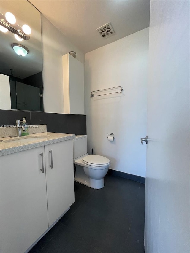 bathroom featuring vanity, tile patterned flooring, and toilet