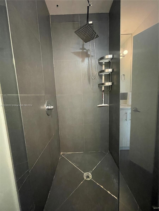 bathroom featuring tiled shower and vanity