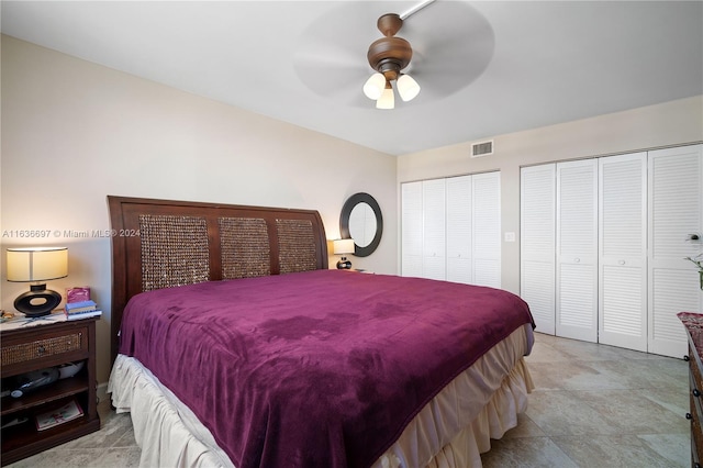 bedroom featuring ceiling fan and multiple closets