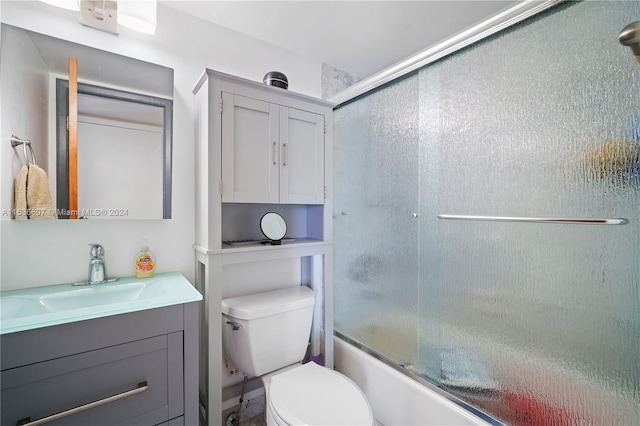 full bathroom featuring enclosed tub / shower combo, vanity, and toilet