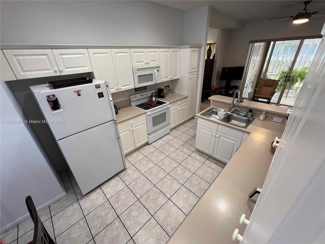 kitchen with light tile patterned floors, a sink, white cabinetry, and white appliances