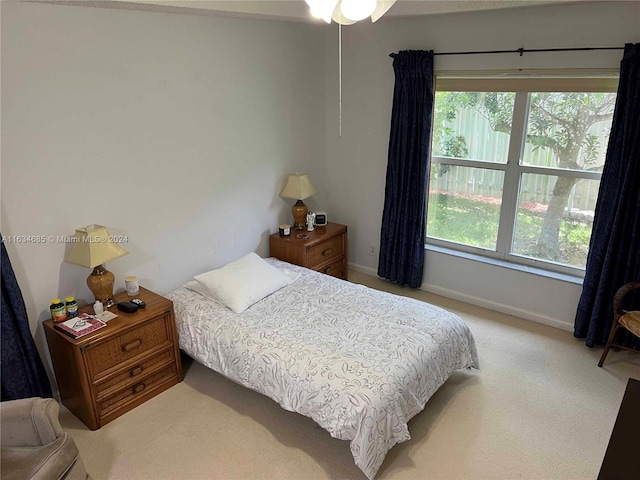 bedroom with multiple windows, baseboards, and carpet floors