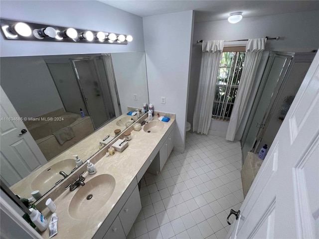 full bath featuring curtained shower, a sink, double vanity, toilet, and tile patterned flooring
