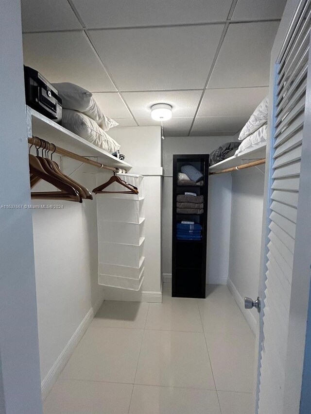 walk in closet featuring a drop ceiling and light tile patterned floors