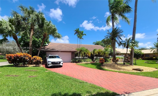 view of front of home featuring a tiled roof, an attached garage, decorative driveway, and a front yard