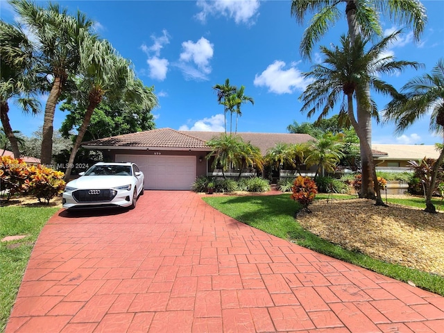 view of front facade featuring decorative driveway, stucco siding, an attached garage, and a tile roof